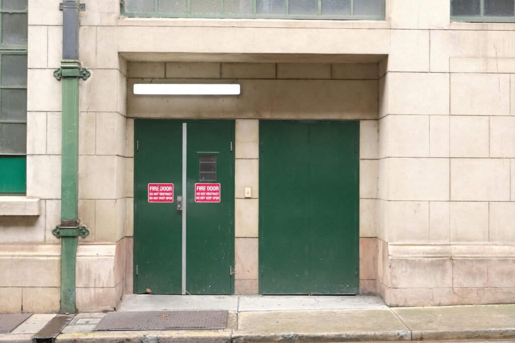 Fire door with warning sign in urban setting, emphasizing safety and compliance.