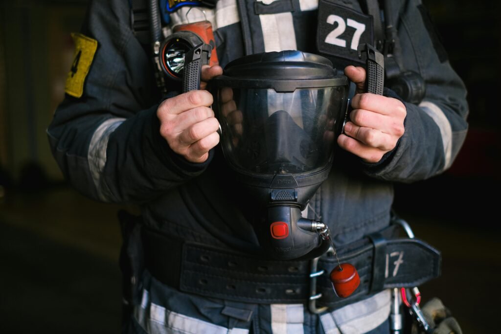 Close-up of a firefighter holding a protective helmet, showcasing emergency gear.